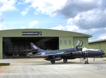 Featured is a photo of the elite delta jets hangar in Gloucestershire, England where individuals wanting to own a piece of a fast and/or classic jet can opt to fractionally own or timeshare an aircraft ... thereby becoming "partsumers".